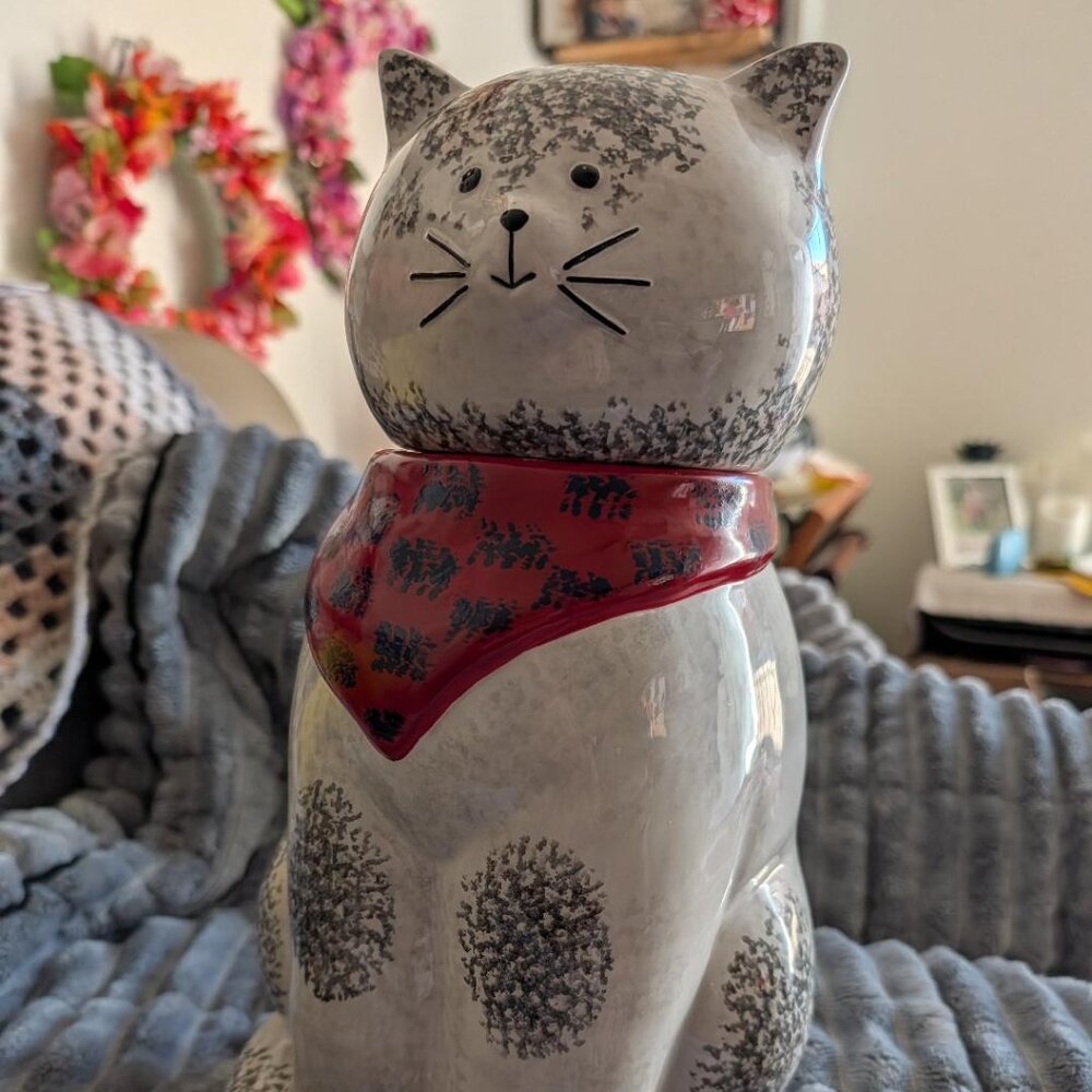 Ceramic cat figurine with speckled design and red bandana
